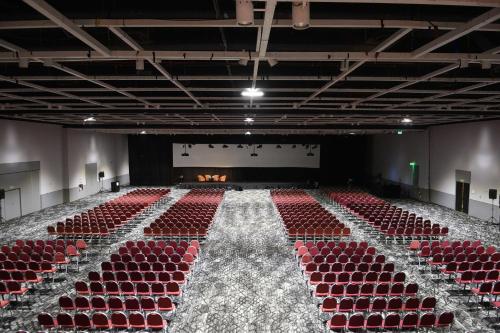 an empty auditorium with red chairs and a stage at Hilton Buenos Aires in Buenos Aires