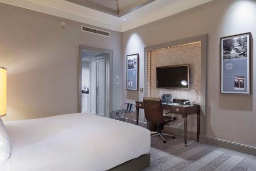 a bedroom with a bed and a desk with a computer at Hilton Bursa Convention Center & Spa in Bursa