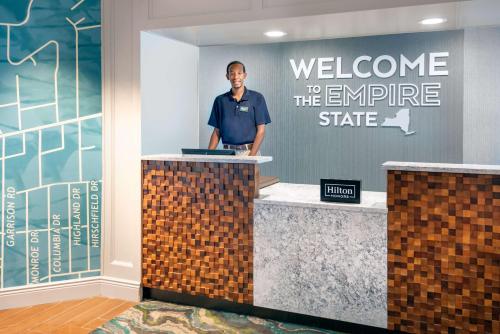 a man standing at a welcome to the empire state building at Hampton Inn Buffalo-Williamsville in Williamsville