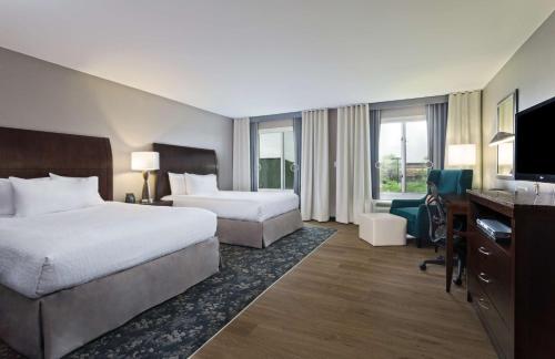 a hotel room with two beds and a desk at Hilton Garden Inn Annapolis in Annapolis