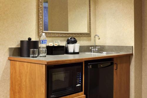 a kitchen with a microwave and a sink at Embassy Suites by Hilton Columbia Greystone in Columbia