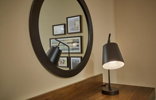 a black lamp and a mirror on a wall at Hampton Inn & Suites Roseburg in Roseburg