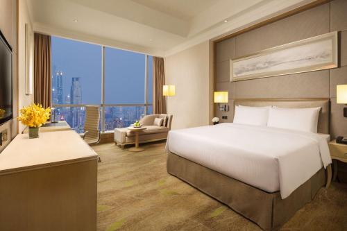 広州市にあるDoubleTree by Hilton Guangzhou-Free Canton Fair Shuttle Bus & Registration Counterのベッドと大きな窓が備わるホテルルームです。