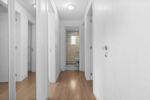 a hallway with white walls and a toilet in a room at Residencial Villa Verde - 403 B in Gramado