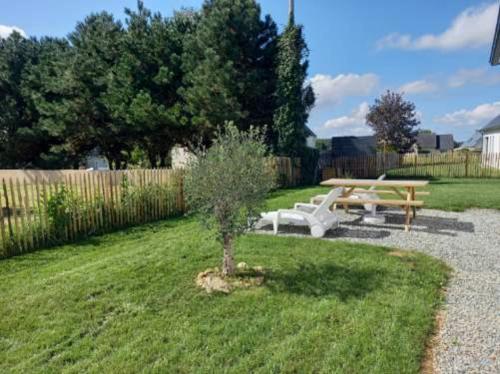 a picnic table and a bench in a yard at Maison neuve à 2 pas des plus belles plages de Douarnenez - Classé Meublé de Tourisme 3 étoiles in Kerlaz