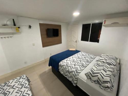 a bedroom with two beds and a television in it at Best House Victoria in Vitória