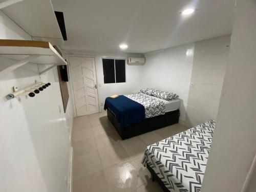 um pequeno quarto com duas camas num quarto em Best House Victoria em Vitória