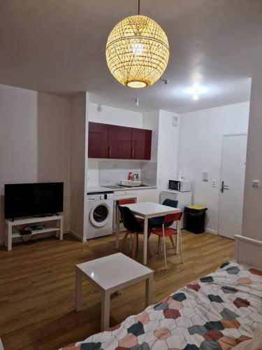 uma sala de estar com uma mesa e uma cozinha em Appartement 20mn Paris Saint Lazare (4 personnes) em Argenteuil