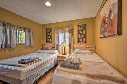 2 camas en una habitación con paredes amarillas en Lucas McCain Cabin 5 Mi to Raystown Lake Launch!, en Huntingdon
