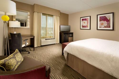 a hotel room with a bed and a desk and a television at Hampton Inn & Suites Chattanooga/Hamilton Place in Chattanooga