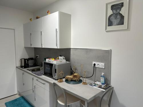 a small kitchen with a table with a microwave at Saint dénis Appartement 1 in Le Mans