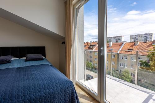 ein Schlafzimmer mit einem Bett und einem großen Fenster in der Unterkunft Apartament Olsztyn Centrum in Olsztyn