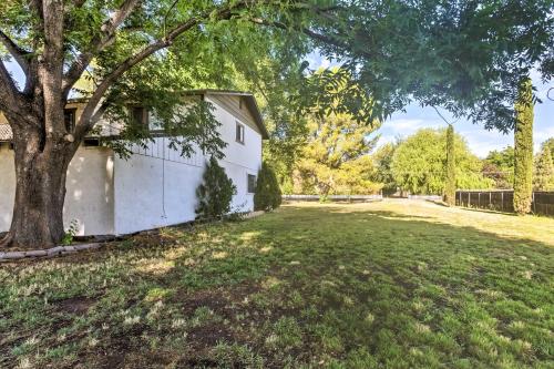 a white house with a tree in the yard at Patio and Yard Dtwn Cottonwood Home! in Cottonwood