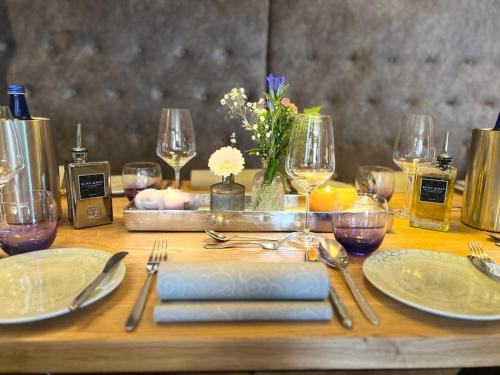 a table with plates and silverware and wine glasses at Landgasthaus Lenniger in Büren