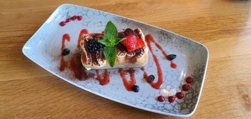 a plate with a piece of toast with fruit on it at Landgasthaus Lenniger in Büren