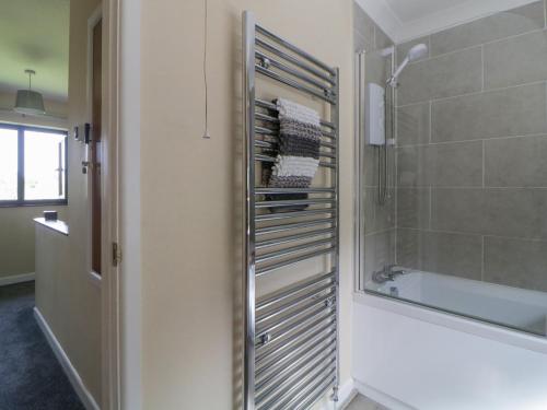 a bathroom with a shower and a towel rack at Moorstone in Okehampton