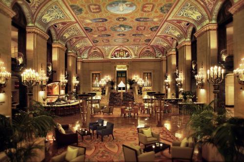 an ornate lobby with a large room with tables and chairs at The Palmer House Hilton in Chicago