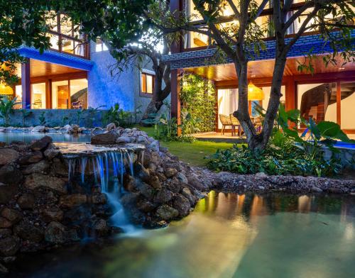 a house with a waterfall in front of a house at Hotel Sombra e Água Fresca in Pipa