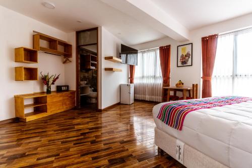 a bedroom with a bed and a wooden floor at Hacienda del Valle Sagrado in Urubamba