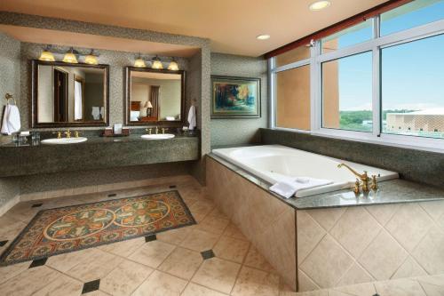 a large bathroom with a tub and a large window at Embassy Suites North Charleston Airport Hotel Convention in Charleston