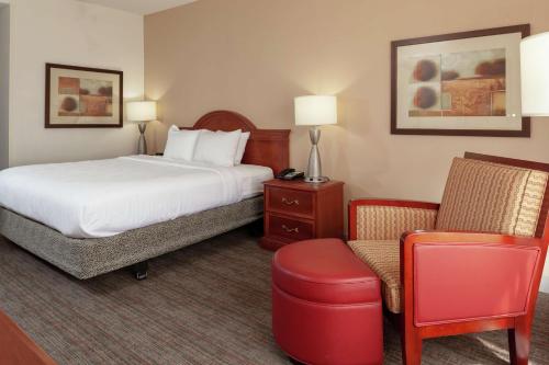 a hotel room with a bed and a chair at Hilton Garden Inn Charlotte North in Charlotte