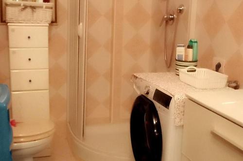 a bathroom with a toilet and a washing machine at Casamia. Confortevole appartamento vicinissimo al mare in Porto Torres