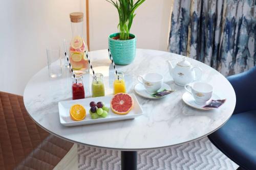 a white table with a plate of fruit on it at Hilton Cobham in Cobham