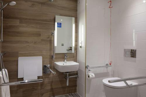 a bathroom with a sink and a toilet and a mirror at Hilton Cobham in Cobham
