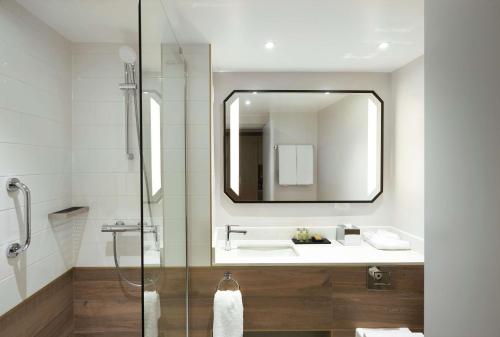 een badkamer met een wastafel en een spiegel bij Hilton Cobham in Cobham