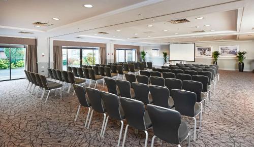 a room with rows of chairs and a whiteboard at Hilton Cobham in Cobham