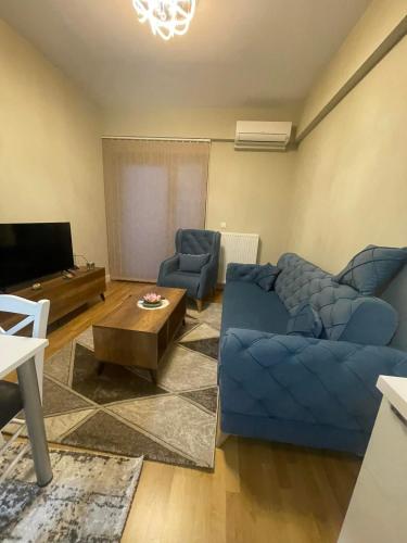 ein Wohnzimmer mit einem blauen Sofa und einem TV in der Unterkunft Diamond one skopje NJ in Skopje