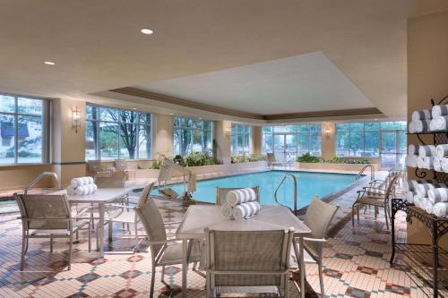 uma sala de bilhar com mesas e cadeiras e uma piscina em Embassy Suites Charleston em Charleston