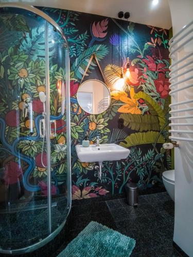 a bathroom with a sink and a colorful wall at Apartamenty Numer 6 in Lublin