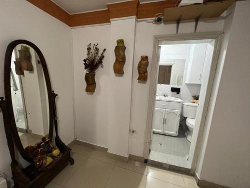 uma casa de banho com um espelho, um lavatório e um WC. em Hermoso y acogedor departamento em Atuntaqui