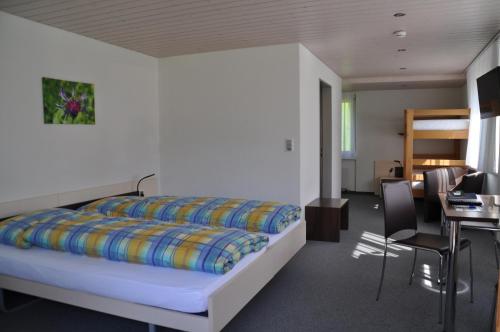a bedroom with a bed and a table and chairs at Ferien- und Familienhotel Alpina Adelboden in Adelboden
