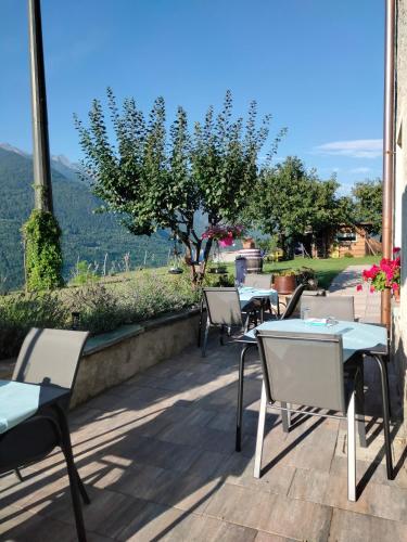 a row of tables and chairs on a patio with a view at Il posto al sole in Teglio