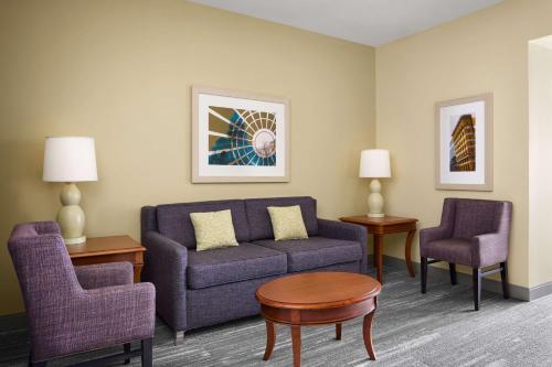 a living room with a couch and two chairs at Hilton Garden Inn Dallas Richardson in Richardson