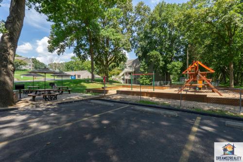 a park with a playground with a slide and picnic tables at 3BR Condo with Lake View - Trout Fishing - Playground - 2 Pools - Stairs Required - FREE TICKETS INCLUDED - PR69-9 in Branson