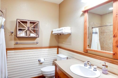 y baño con aseo, lavabo y espejo. en Pet-Friendly Silver Mountain Studio Mountain View, en Kellogg