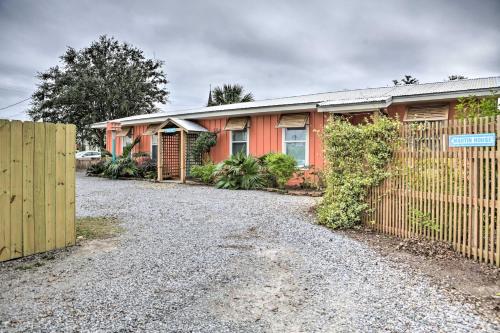 a house with a fence next to a gravel driveway at Walk to Beach from Chic Old Town Apartment with Yard in Bay Saint Louis