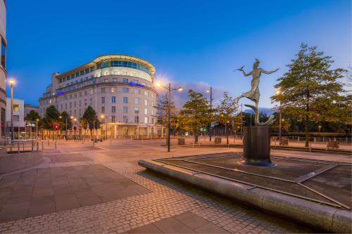 a statue of a woman in a plaza in front of a building at Hilton Cardiff in Cardiff