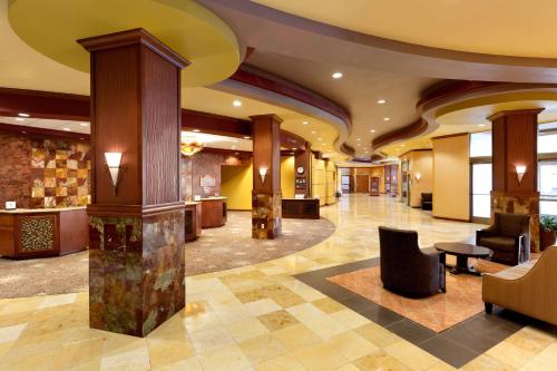 a lobby of a hotel with chairs and tables at Embassy Suites by Hilton Dallas Frisco Hotel & Convention Center in Frisco
