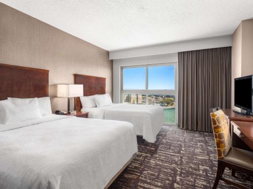 una camera d'albergo con due letti e una televisione di Embassy Suites by Hilton Dallas Frisco Hotel & Convention Center a Frisco