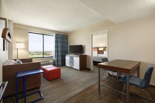 a hotel room with a bed and a desk and a room at Hampton Inn & Suites Dallas-Mesquite in Mesquite
