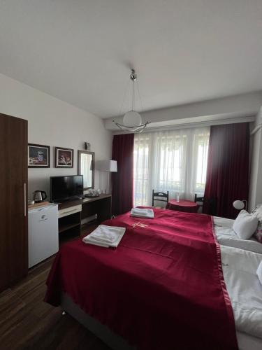 a bedroom with a large bed with a red blanket at Villa Malezan in Ohrid
