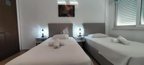 2 camas en una habitación con paredes y ventanas blancas en Arslan Villa with Pool en Marmaris