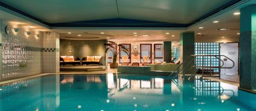 a swimming pool in a hotel with a lobby at Hilton Dresden an der Frauenkirche in Dresden