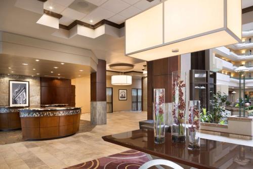 a lobby of a hotel with a table with vases on it at Embassy Suites Des Moines Downtown in Des Moines