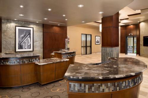 a hotel lobby with a counter and a bar at Embassy Suites Des Moines Downtown in Des Moines