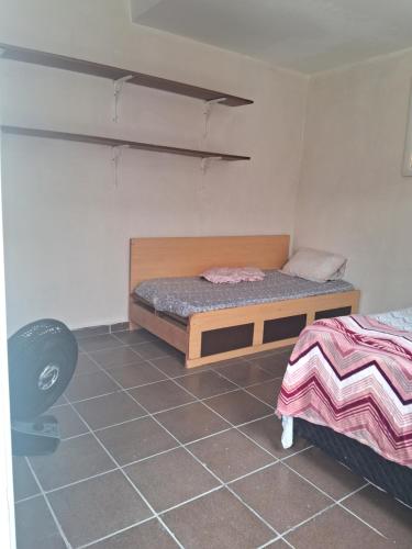 1 dormitorio con 1 cama y 1 silla en Loft Praia do Sonho, en Itanhaém